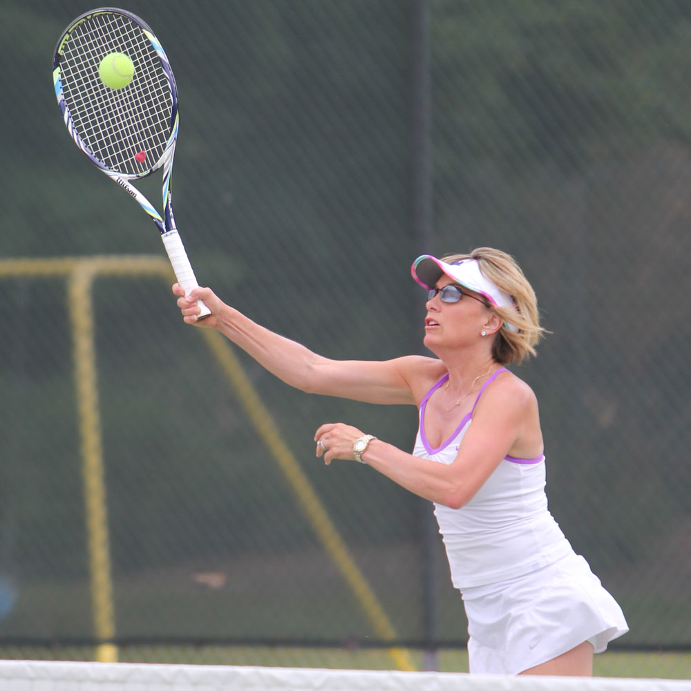 Sue Clark hitting a high volley